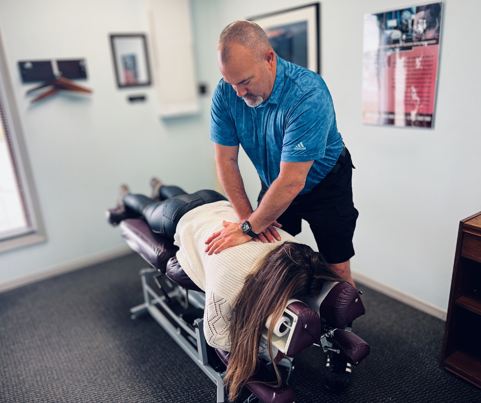 Your First Visit - Dr. Michael Hartle performing an adjustment on his patient in his clinic.