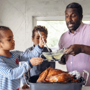 Thanksgiving turkey with a dad and two kids making gravy.